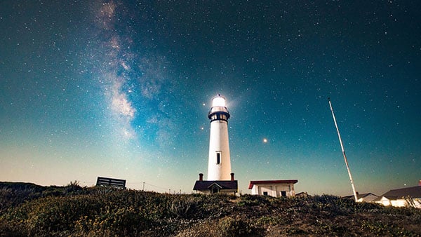 lighthouse shining in the dark sky