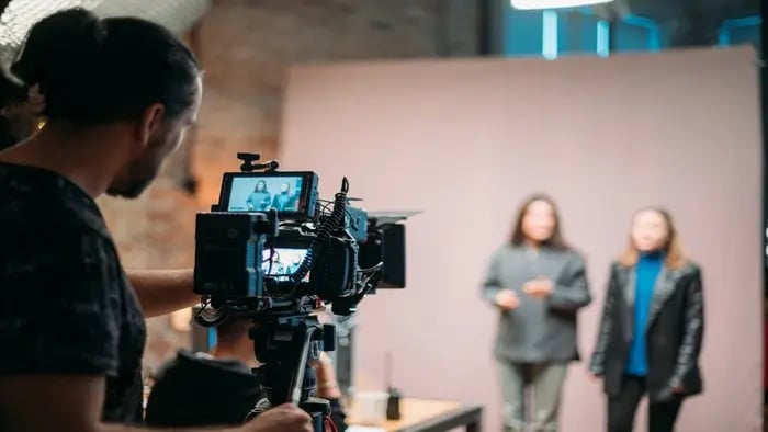 Image of a videographer filming two individuals